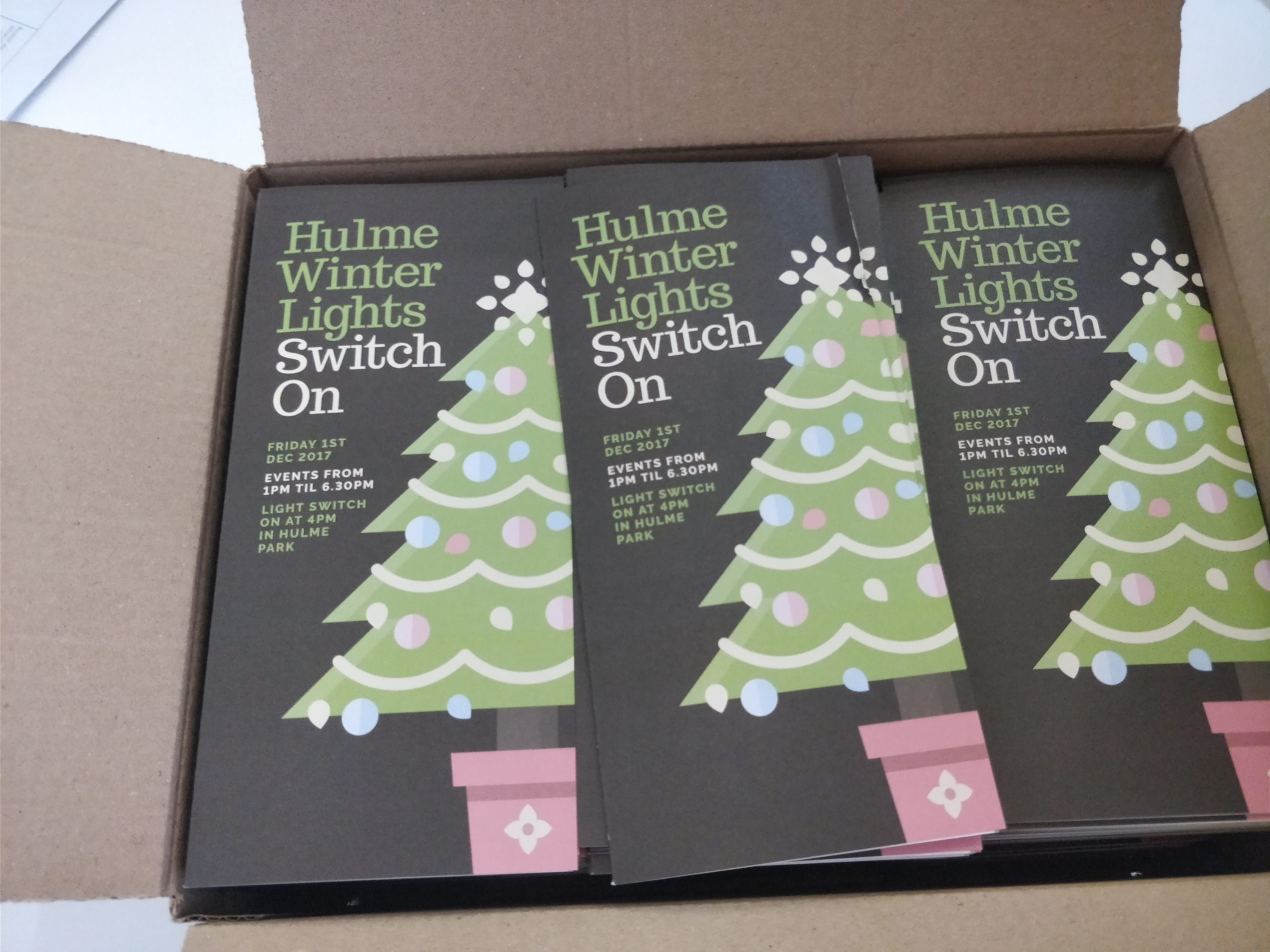 A box of hulme winter lights switch on leaflets