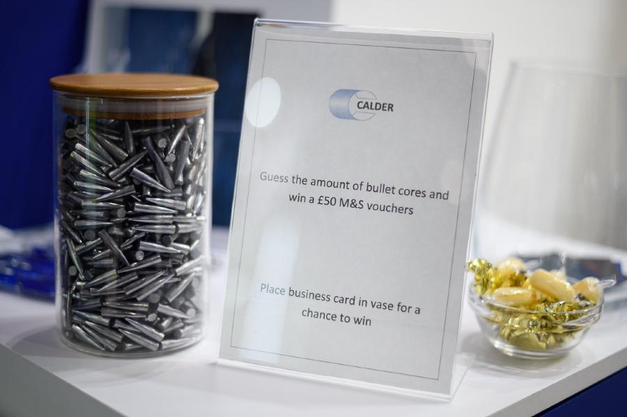 A jar of bullets with a sign reading 'Guess the amount of bullet cores and win a £50 M&S voucher. Place business card in vase for a chance to win
